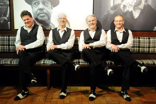 Jazzquartett in Westen und Fliegen auf einem Sofa